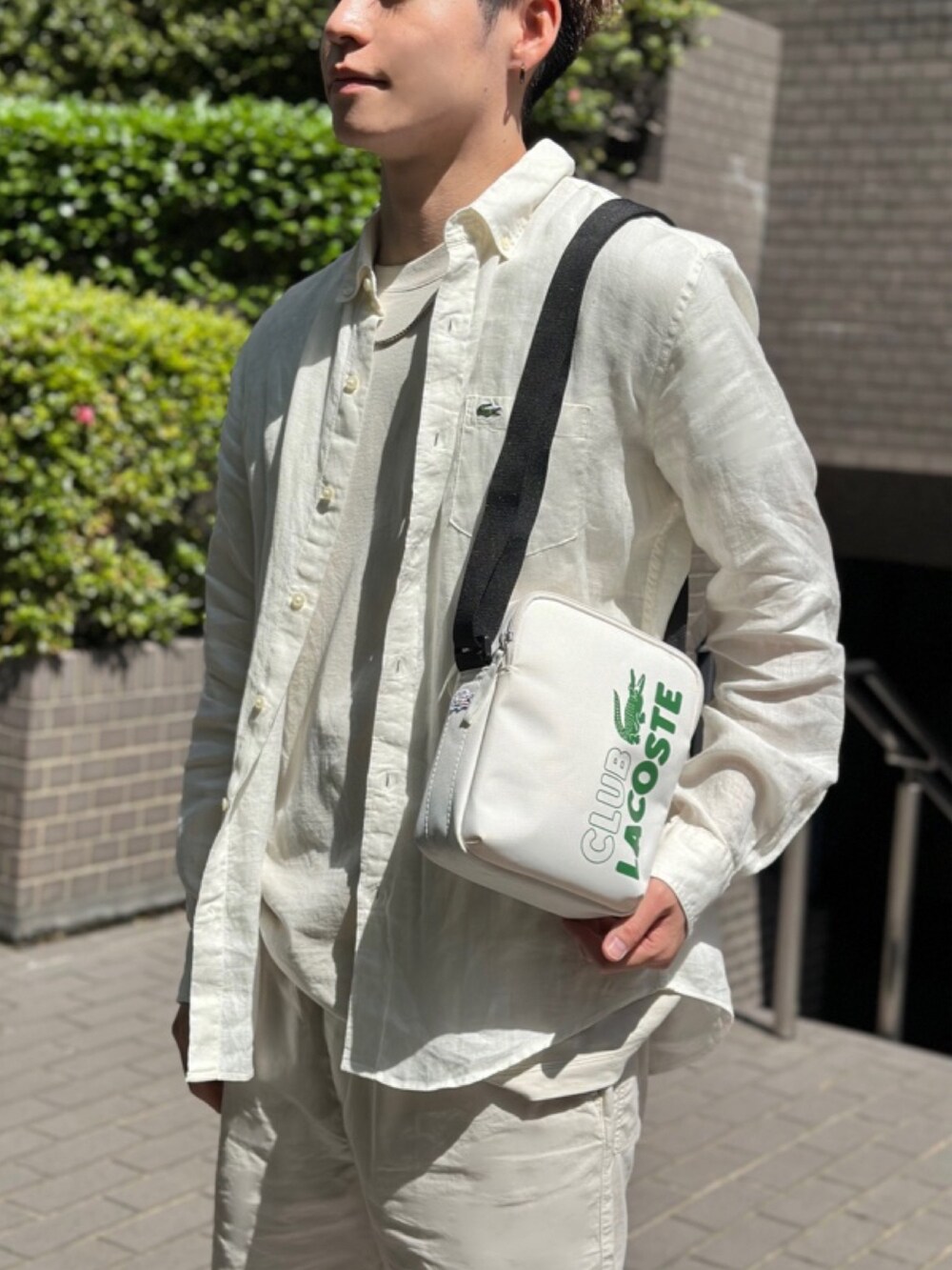 ベージュ系のTシャツ/カットソー、ベージュ系のその他パンツ、ホワイト系のショルダーバッグを着用したメンズの春コーディネートの6枚目の写真