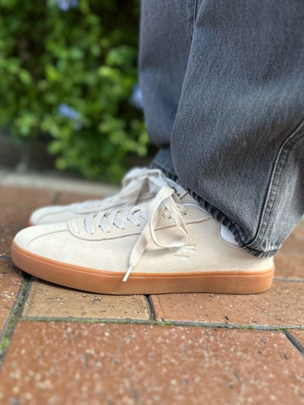 ブラウン系のブルゾン、ブルー系のニット/セーター、ブラック系のデニムパンツを着用したメンズの春コーディネートの8枚目の写真