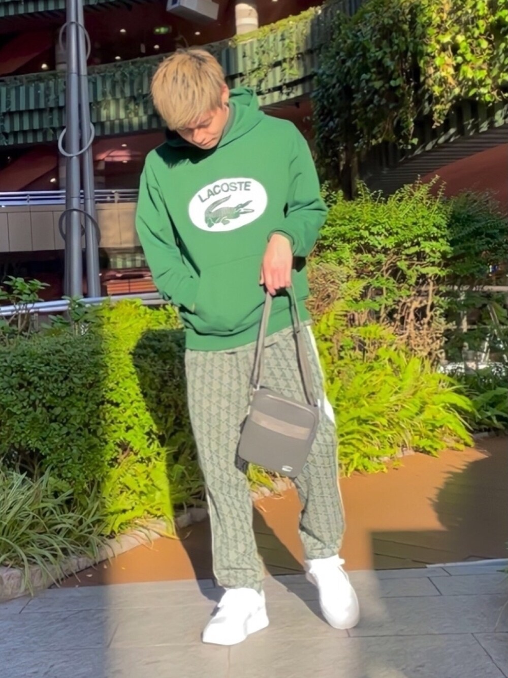 グリーン系のダウンジャケット/コート、グレー系のバッグ、グリーン系のスウェットを着用したメンズの春コーディネートの4枚目の写真