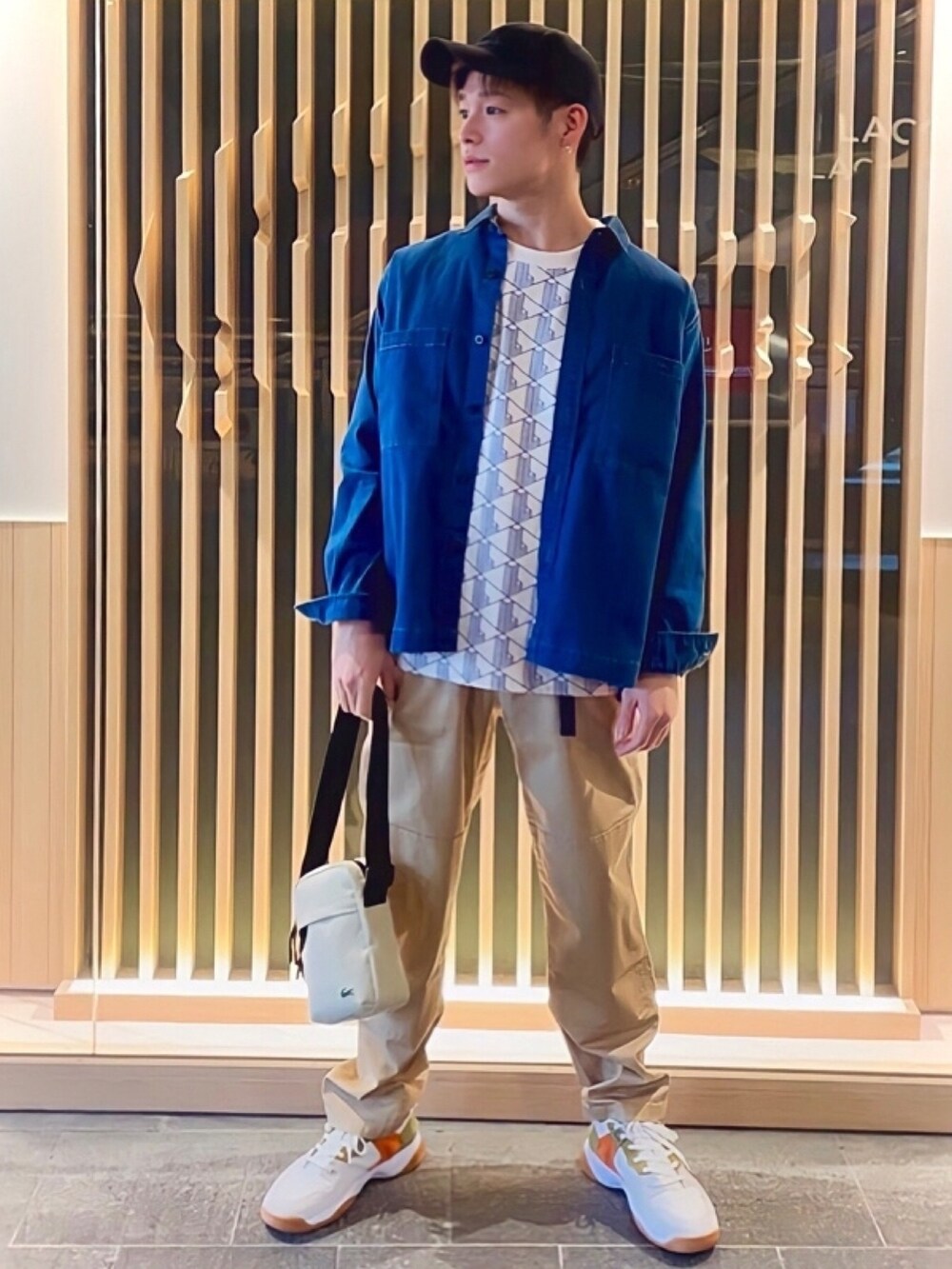 ホワイト系のTシャツ/カットソー、ホワイト系のスニーカー、ベージュ系のショルダーバッグを着用したメンズの秋コーディネートの2枚目の写真