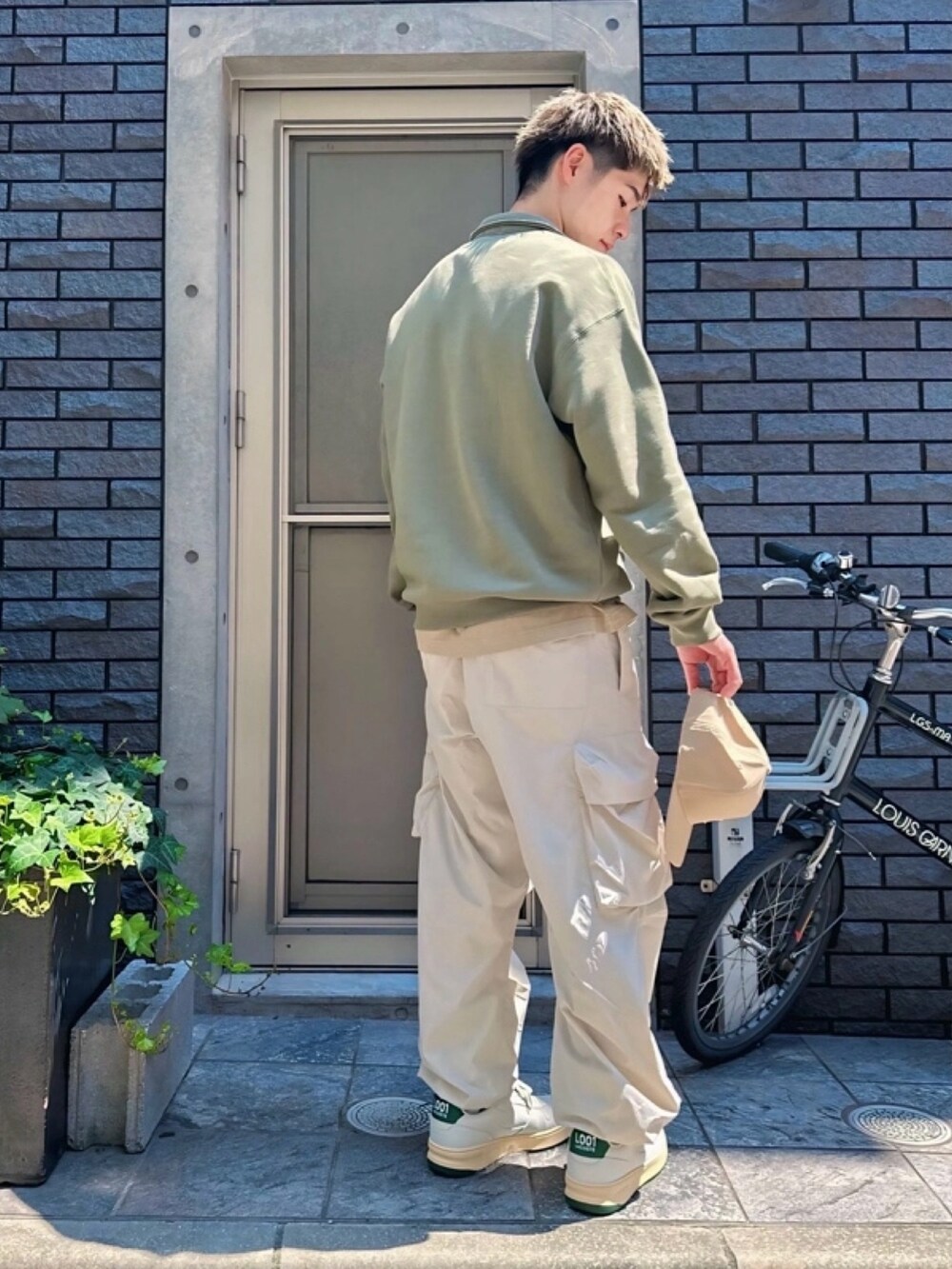 ホワイト系のカーゴパンツ、ホワイト系のスニーカー、ベージュ系のTシャツ/カットソーを着用したメンズの春コーディネートの3枚目の写真