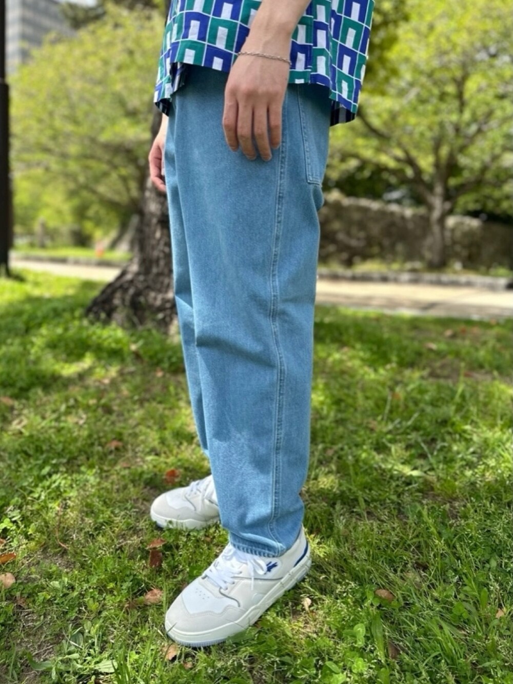 ブルー系のシャツ/ブラウス、グレー系のデニムパンツ、ベージュ系のトートバッグを着用したメンズの春コーディネートの3枚目の写真