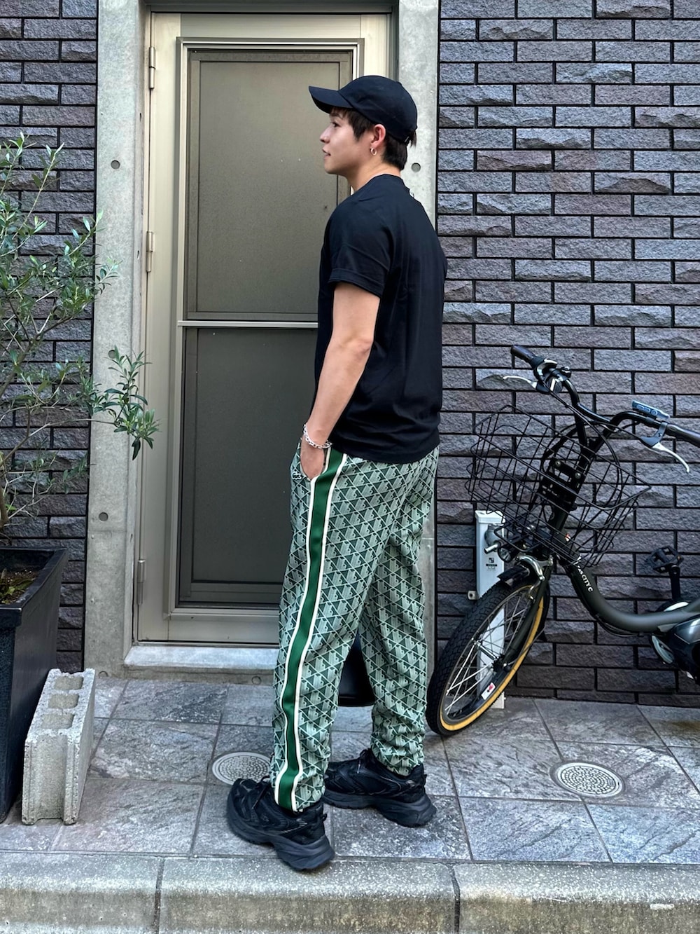 ブラック系のTシャツ/カットソー、グリーン系のスウェットパンツ、ブラック系のショルダーバッグを着用したメンズの秋コーディネートの3枚目の写真