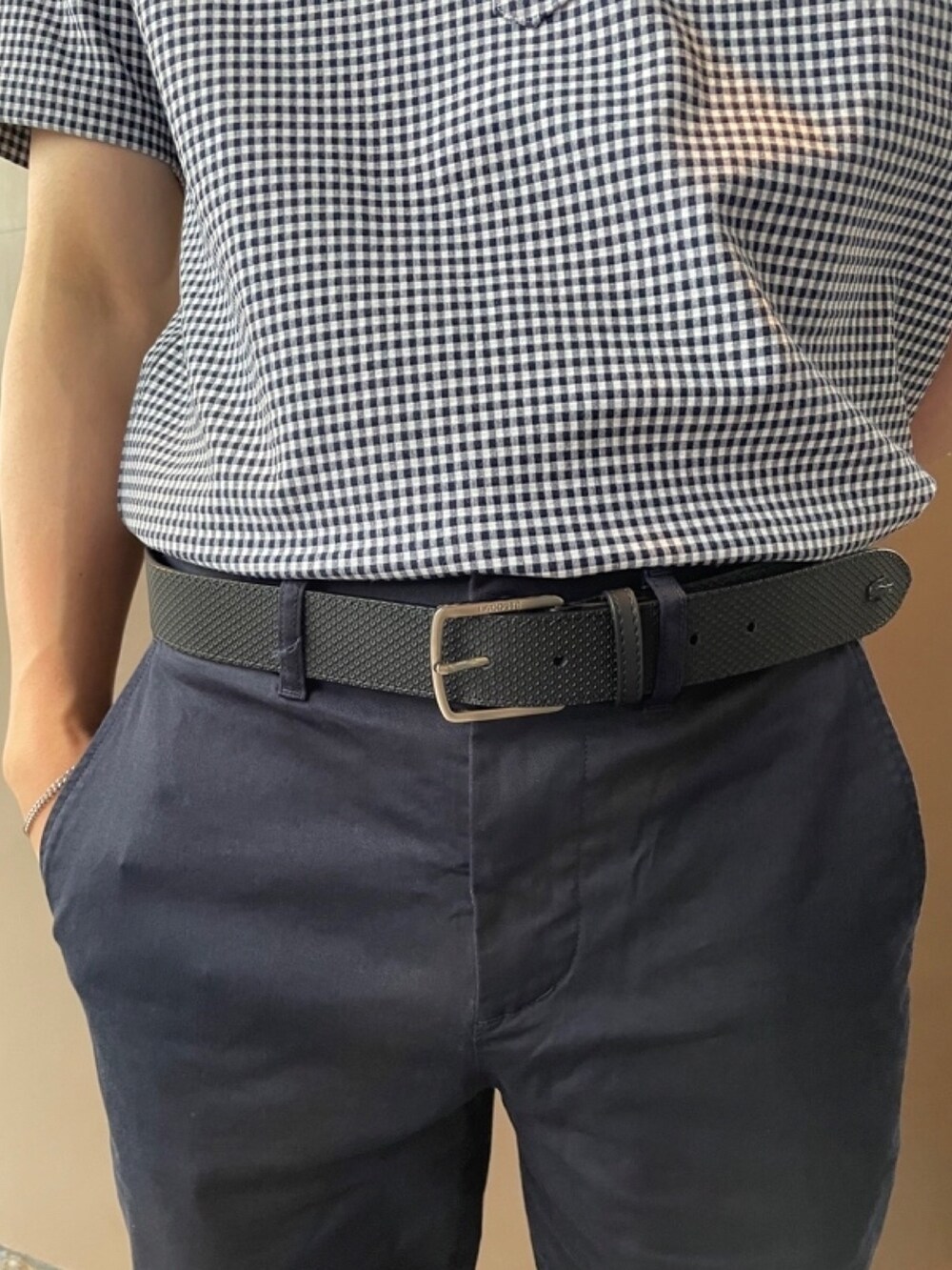 ブラック系のショルダーバッグ、ブルー系のチノパンツ、ホワイト系のスニーカーを着用したメンズの秋コーディネートの5枚目の写真