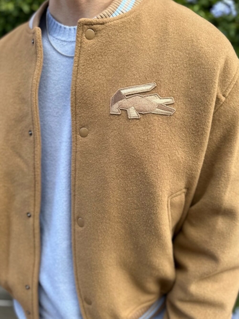 ブラウン系のブルゾン、ブルー系のニット/セーター、ブラック系のデニムパンツを着用したメンズの春コーディネートの5枚目の写真