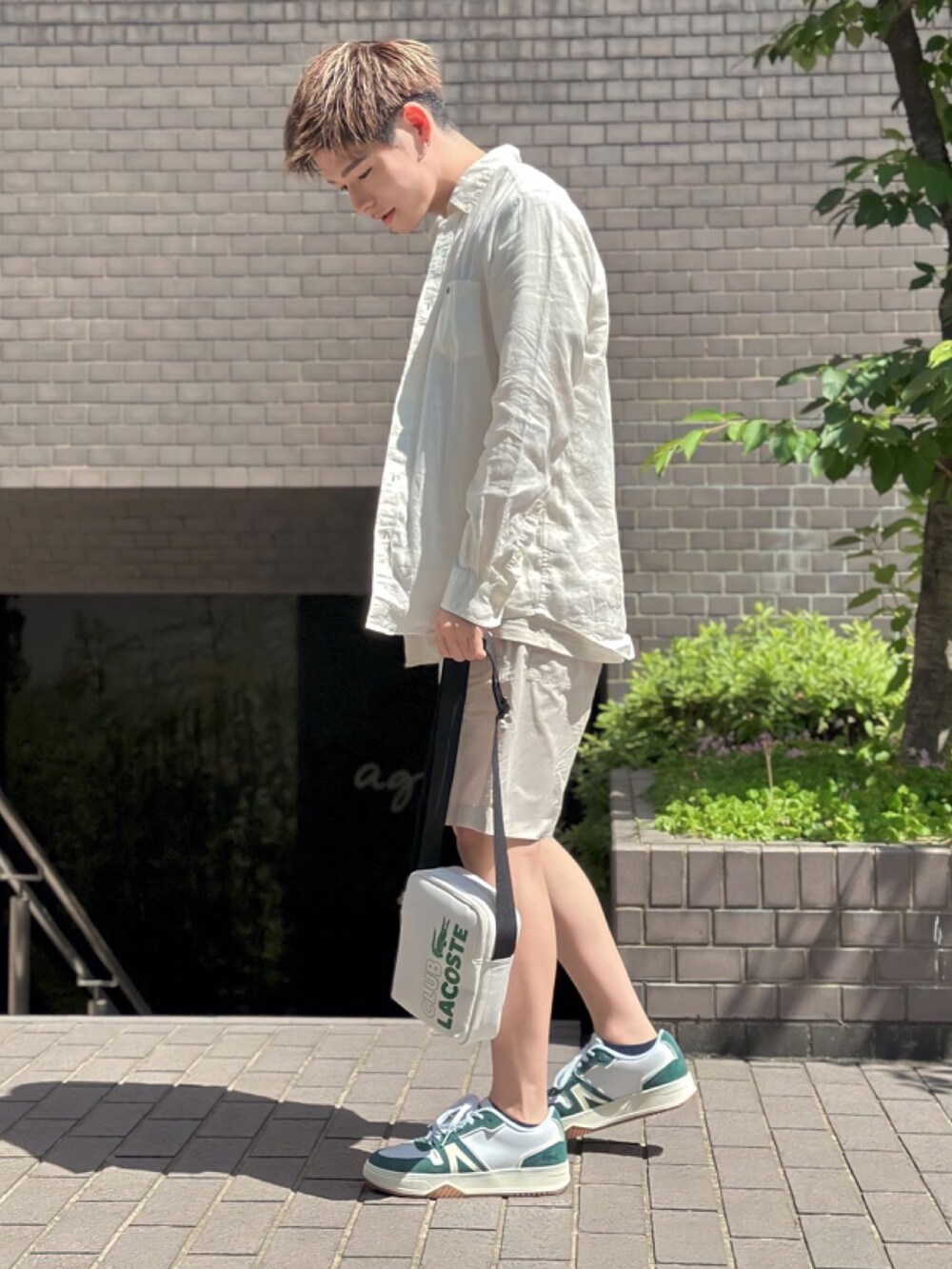 ベージュ系のTシャツ/カットソー、ベージュ系のその他パンツ、ホワイト系のショルダーバッグを着用したメンズの春コーディネートの2枚目の写真