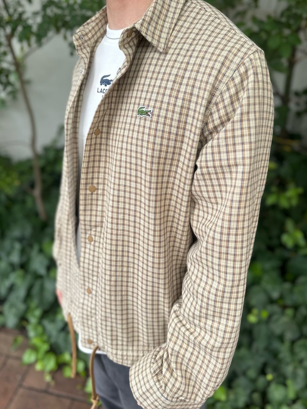 ホワイト系のTシャツ/カットソー、ベージュ系のシャツ/ブラウス、ブラック系のデニムパンツを着用したメンズの秋コーディネートの6枚目の写真