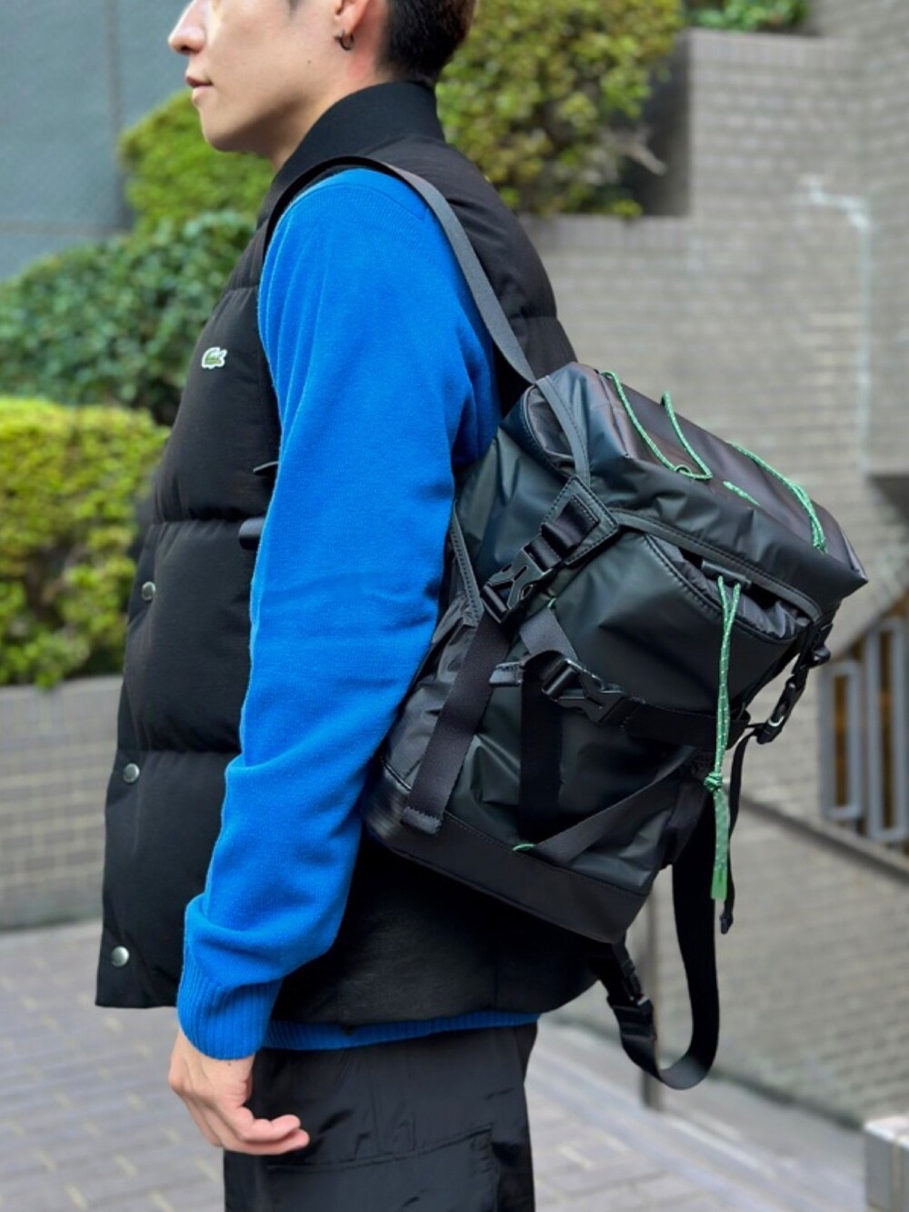 ブラック系のカーゴパンツ、ブラック系のスニーカー、ブラック系のダウンベストを着用したメンズの春コーディネートの4枚目の写真