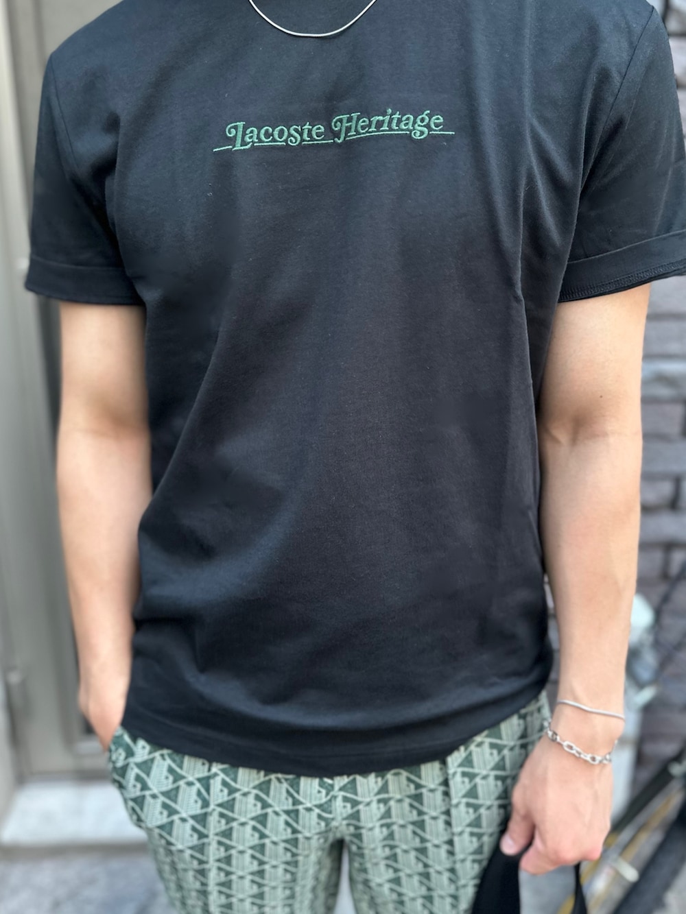 ブラック系のTシャツ/カットソー、グリーン系のスウェットパンツ、ブラック系のショルダーバッグを着用したメンズの秋コーディネートの5枚目の写真