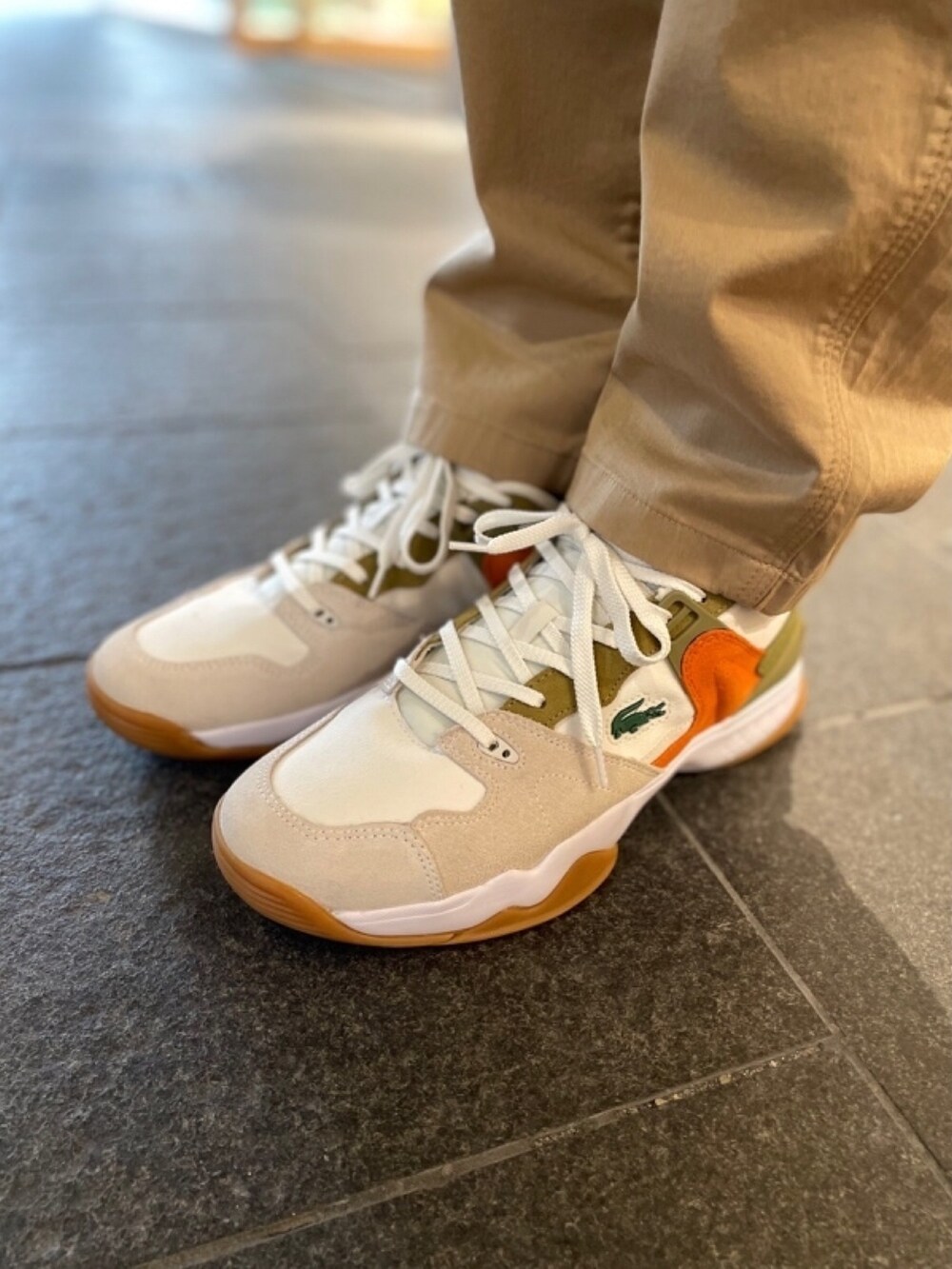 ホワイト系のTシャツ/カットソー、ホワイト系のスニーカー、ベージュ系のショルダーバッグを着用したメンズの秋コーディネートの5枚目の写真