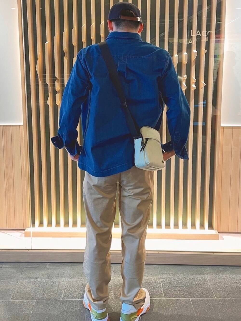 ホワイト系のTシャツ/カットソー、ホワイト系のスニーカー、ベージュ系のショルダーバッグを着用したメンズの秋コーディネートの3枚目の写真