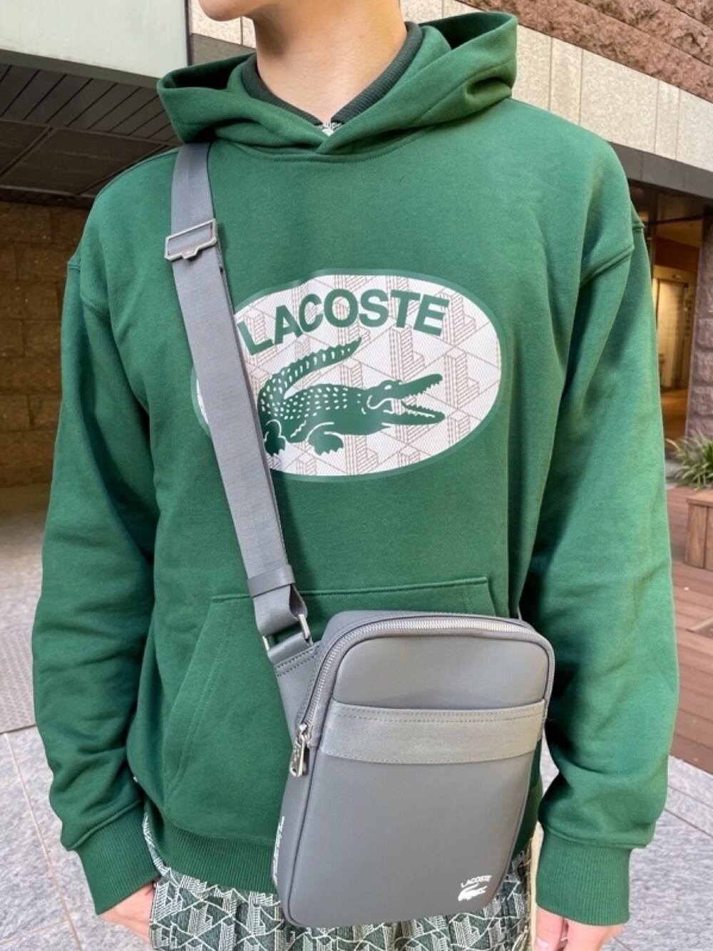 グリーン系のダウンジャケット/コート、グレー系のバッグ、グリーン系のスウェットを着用したメンズの春コーディネートの5枚目の写真