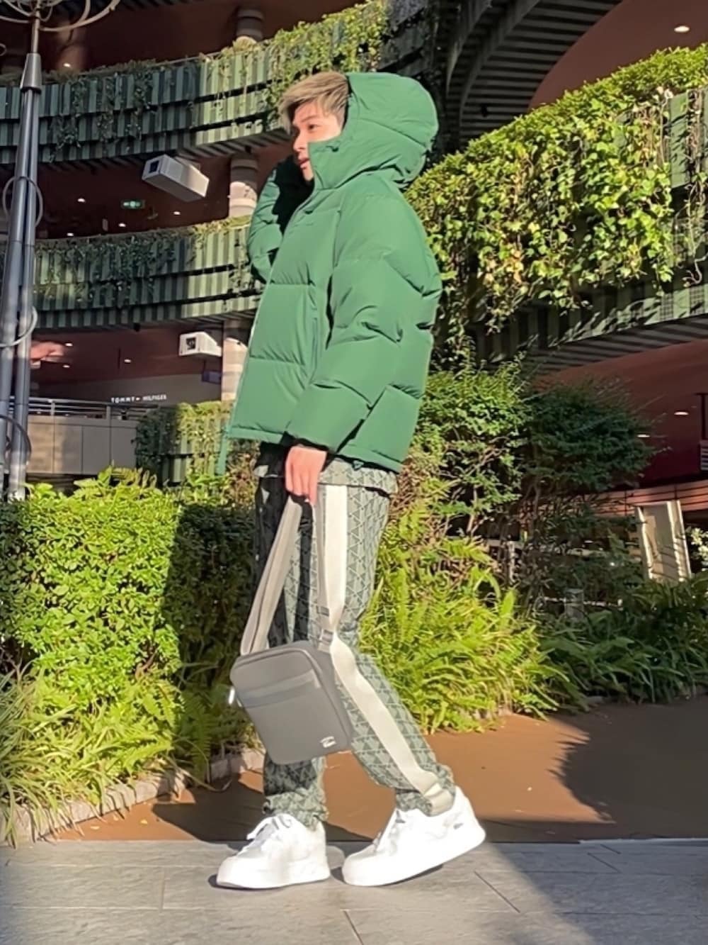 グリーン系のダウンジャケット/コート、グレー系のバッグ、グリーン系のスウェットを着用したメンズの春コーディネートの3枚目の写真