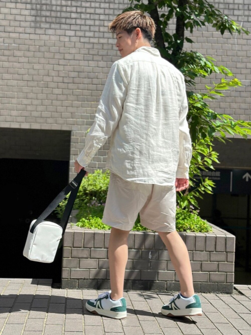 ベージュ系のTシャツ/カットソー、ベージュ系のその他パンツ、ホワイト系のショルダーバッグを着用したメンズの春コーディネートの5枚目の写真