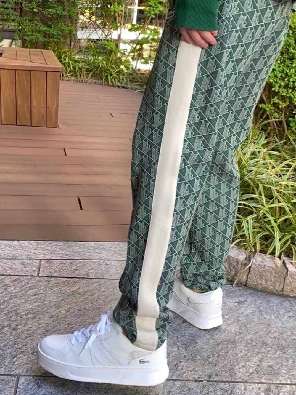 グリーン系のダウンジャケット/コート、グレー系のバッグ、グリーン系のスウェットを着用したメンズの春コーディネートの6枚目の写真