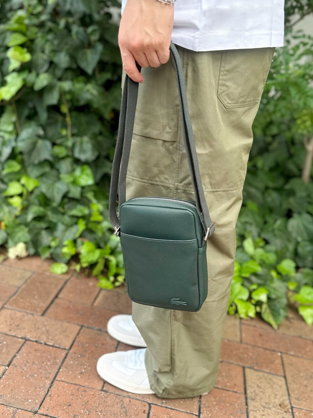 ホワイト系のTシャツ/カットソー、グリーン系のショルダーバッグ、ホワイト系のスニーカーを着用したメンズの秋コーディネートの5枚目の写真