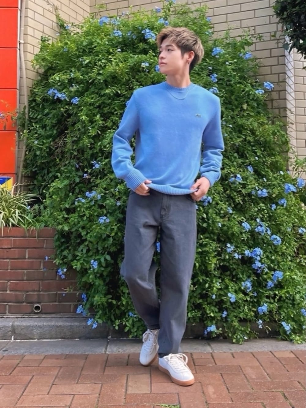 ブラウン系のブルゾン、ブルー系のニット/セーター、ブラック系のデニムパンツを着用したメンズの春コーディネートの3枚目の写真