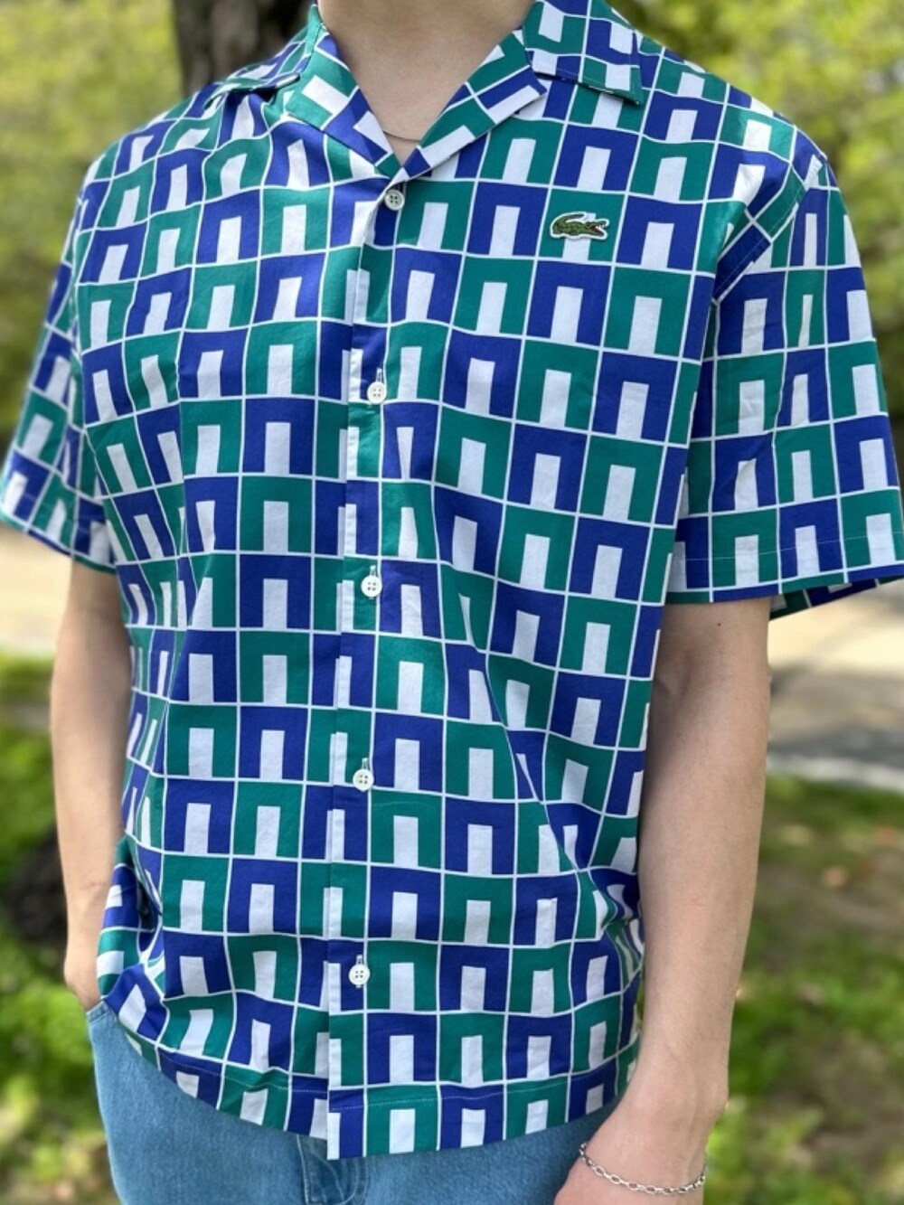 ブルー系のシャツ/ブラウス、グレー系のデニムパンツ、ベージュ系のトートバッグを着用したメンズの春コーディネートの2枚目の写真