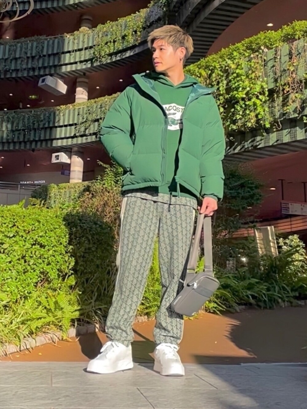 グリーン系のダウンジャケット/コート、グレー系のバッグ、グリーン系のスウェットを着用したメンズの春コーディネートの2枚目の写真