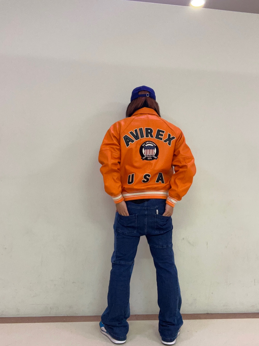 「AVIREX、AVIREX横浜、ファッションの力を信じよう、秋服まるっと大公開、秋コーデ、レザージャケット、オレンジ、ジーンズ、セミフレアパンツ、キャップ」｜「AVIREXの【× NEW ERA】MLB × AVIREX 9サーティ ドジャース ベースボール キャップ / 9THRTY Dodgers BASEBALL CAP（キャップ、ブルー系）」を使った、nakagawa  jinさん（メンズ・170cm）の秋コーディネートの2枚目の写真