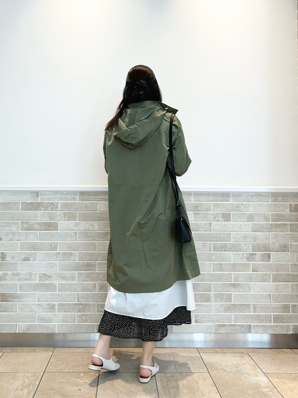 グリーン系のその他アウター、ブラック系のスカート、ホワイト系のその他シューズを着用したレディースの春コーディネートの2枚目の写真