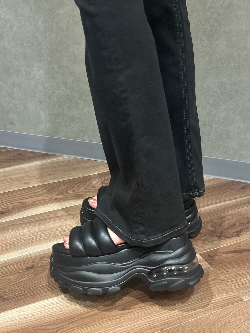 ブラック系のサンダル、ブラック系のデニムパンツ、グレー系のニット/セーターを着用したレディースの夏コーディネートの6枚目の写真