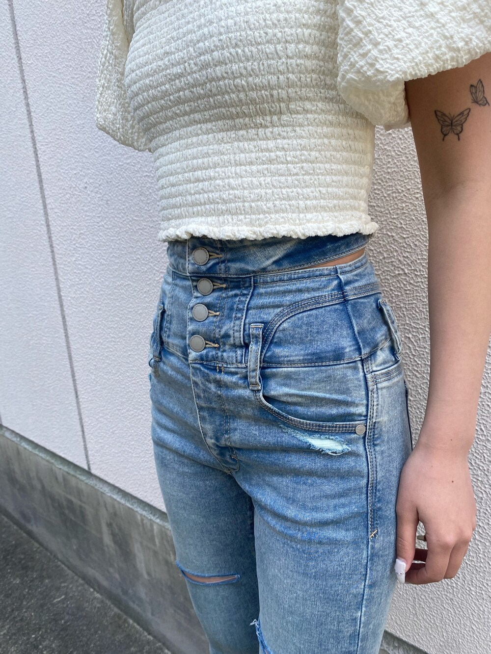 ブラック系のサンダル、ブルー系のデニムパンツ、ホワイト系のTシャツ/カットソーを着用したレディースの春コーディネートの6枚目の写真