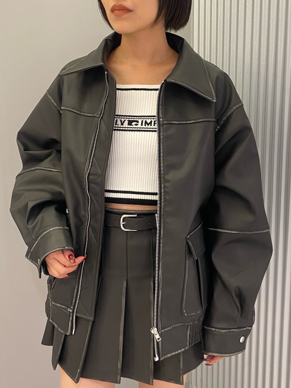 ブラック系のブルゾン、ブラック系のブーツ、ホワイト系のニット/セーターを着用したレディースの秋コーディネートの4枚目の写真