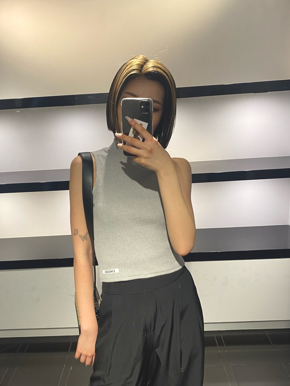 グレー系のタンクトップ、ベージュ系のショルダーバッグ、ブラック系のその他パンツを着用したレディースの夏コーディネートの5枚目の写真