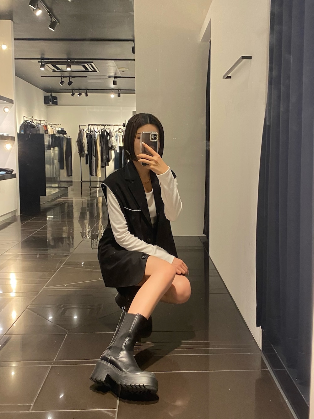 ホワイト系のTシャツ/カットソー、ブラック系のベスト、ブラック系のスカートを着用したレディースの夏コーディネートの6枚目の写真