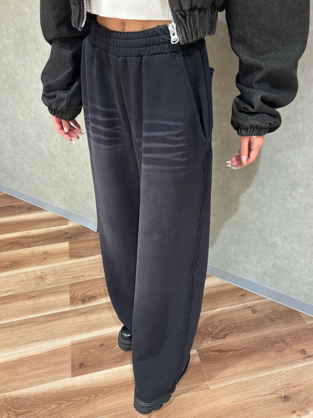 ブラック系のブーツ、ブラック系のブルゾン、ホワイト系のニット/セーターを着用したレディースの秋コーディネートの6枚目の写真