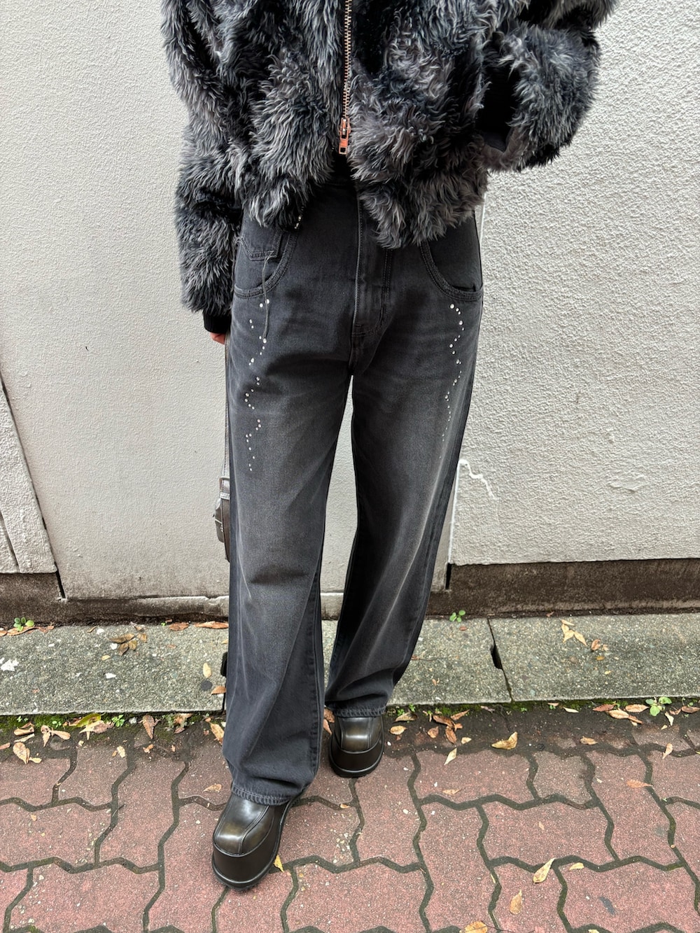 ブラック系のニット/セーター、ブラック系のデニムパンツ、その他のブルゾンを着用したレディースの秋コーディネートの5枚目の写真