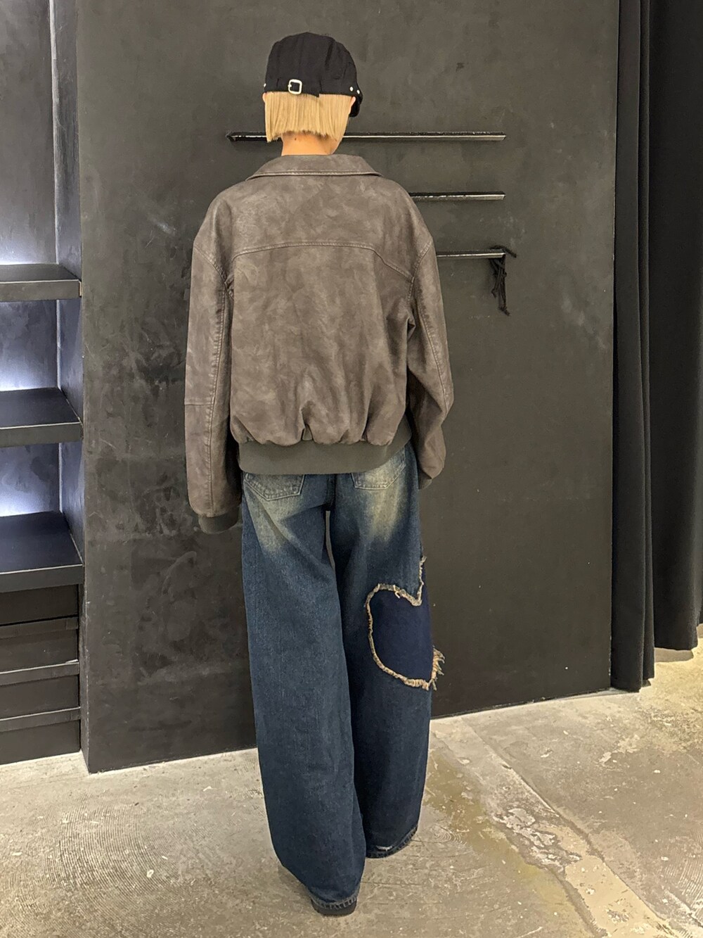 ブルー系のデニムパンツ、ブラック系のニット/セーター、グレー系のブルゾンを着用したレディースの秋コーディネートの3枚目の写真