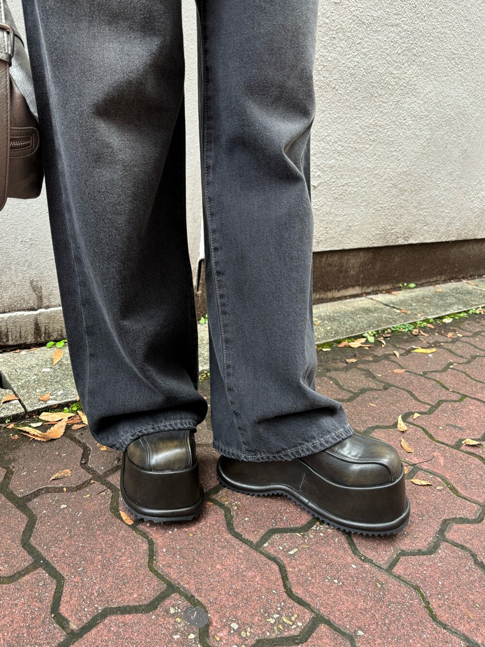 ブラック系のニット/セーター、ブラック系のデニムパンツ、その他のブルゾンを着用したレディースの秋コーディネートの6枚目の写真