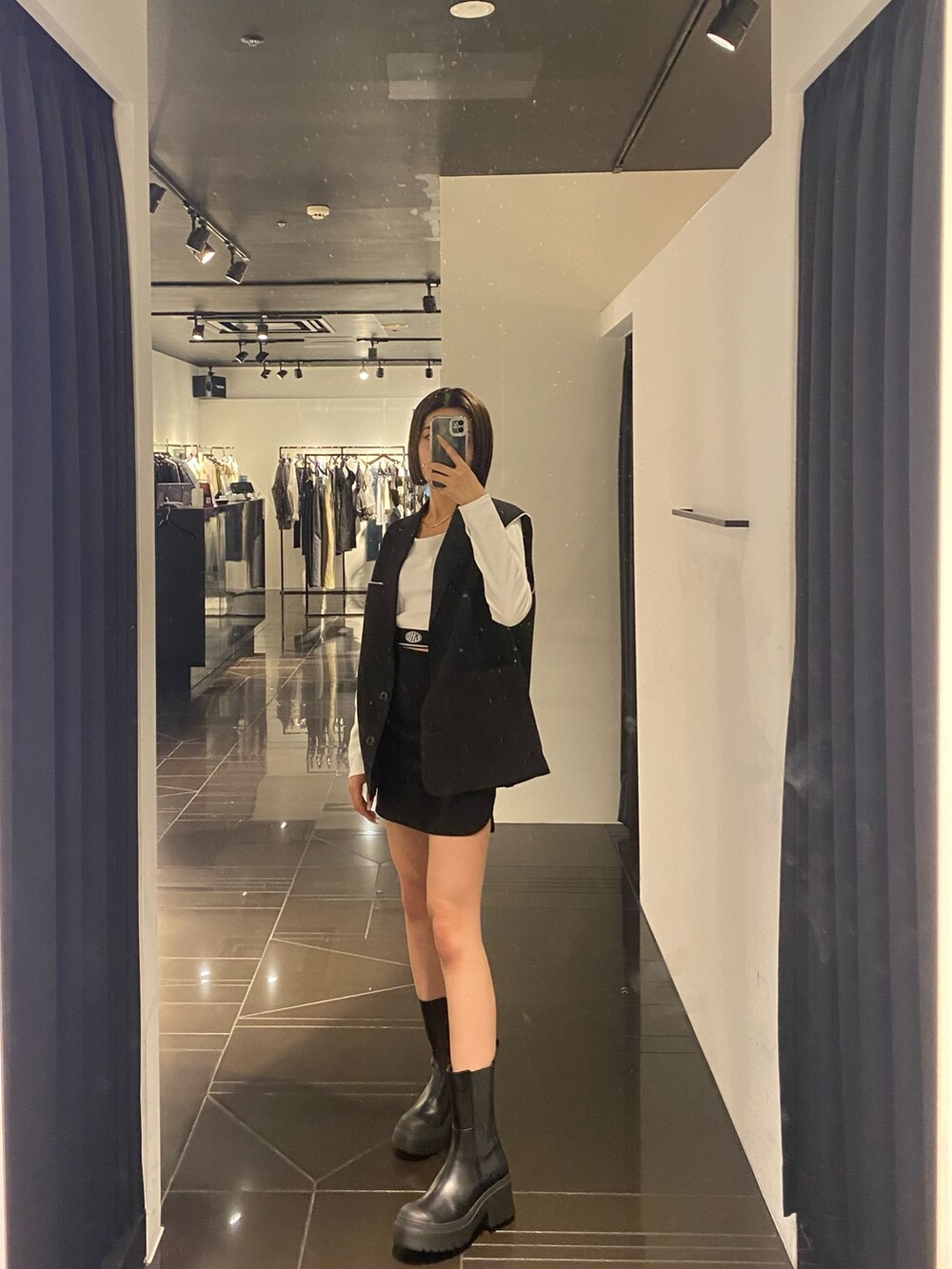 ホワイト系のTシャツ/カットソー、ブラック系のベスト、ブラック系のスカートを着用したレディースの夏コーディネートの3枚目の写真