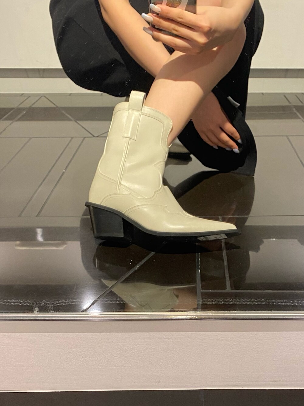 ホワイト系のブーツ、その他のハンドバッグ、ブラック系のワンピースを着用したレディースの春コーディネートの6枚目の写真