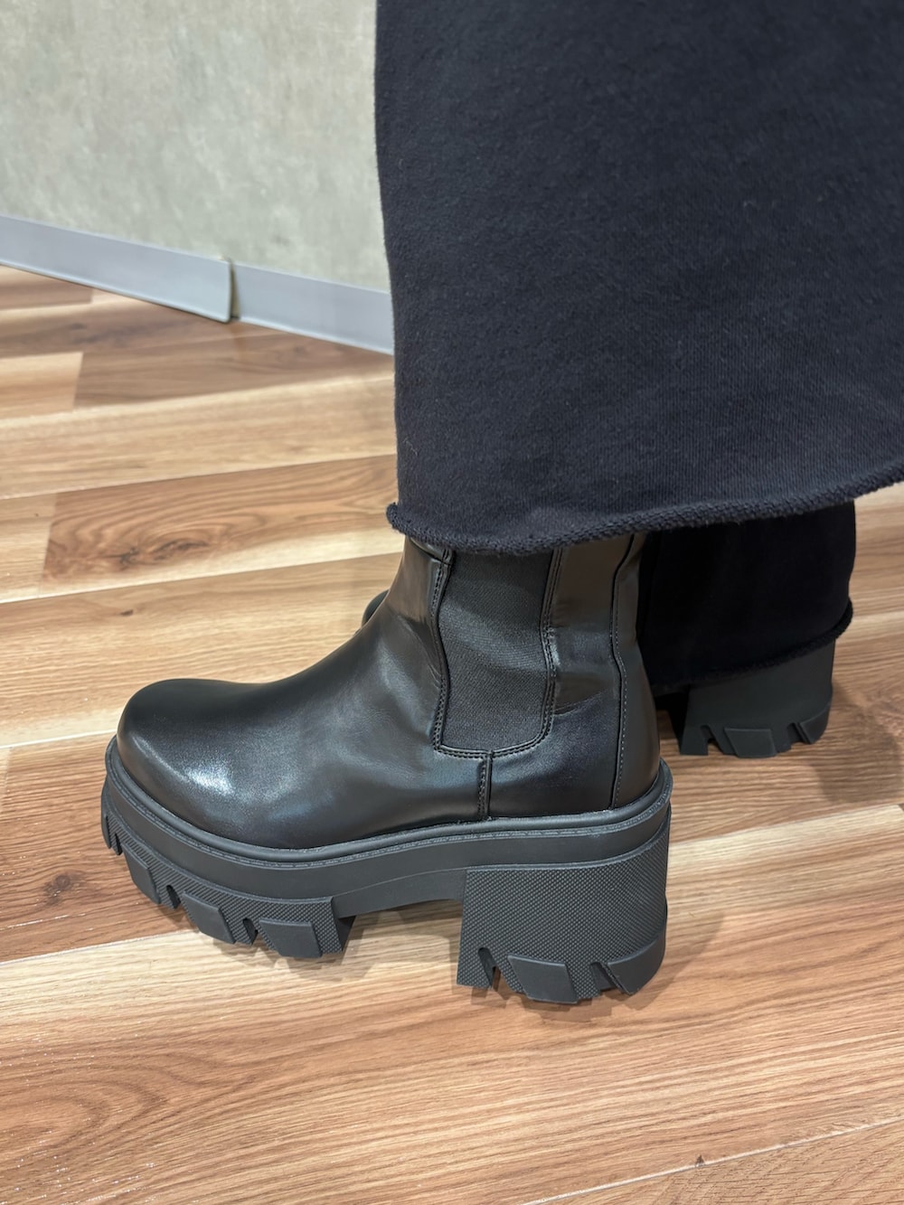 ブラック系のブーツ、ブラック系のブルゾン、ホワイト系のニット/セーターを着用したレディースの秋コーディネートの7枚目の写真