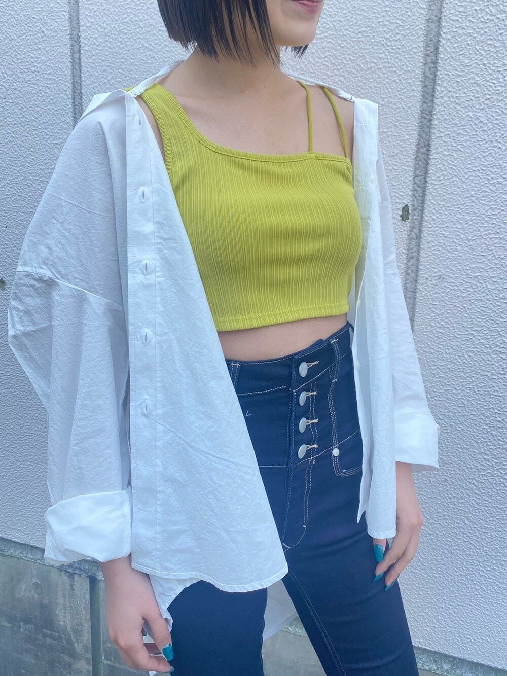 ホワイト系のシャツ/ブラウス、イエロー系のタンクトップ、ホワイト系のサンダルを着用したレディースの春コーディネートの3枚目の写真