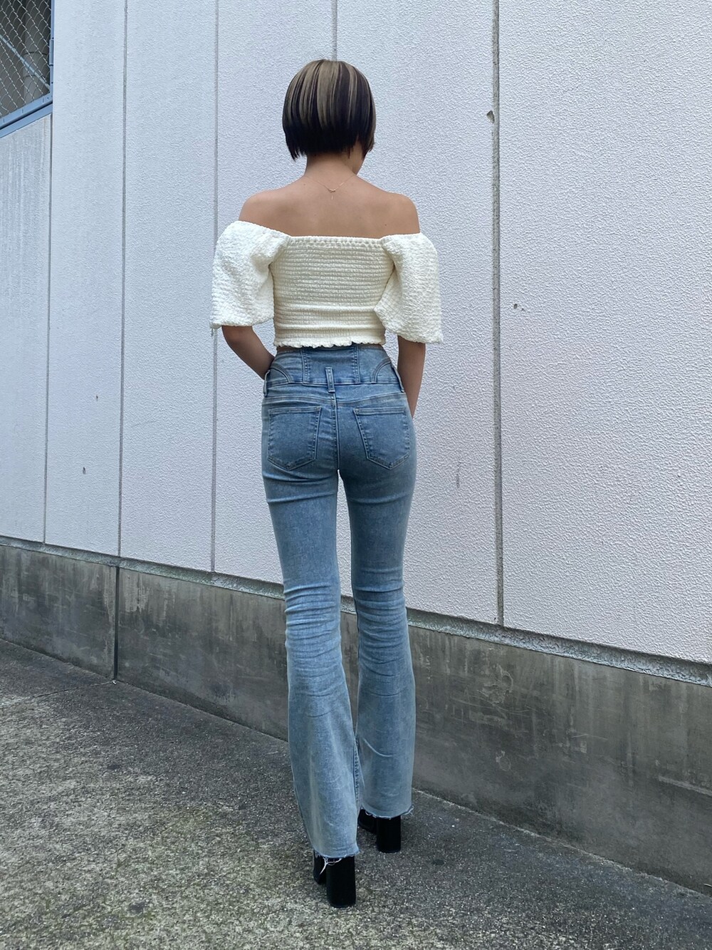 ブラック系のサンダル、ブルー系のデニムパンツ、ホワイト系のTシャツ/カットソーを着用したレディースの春コーディネートの3枚目の写真