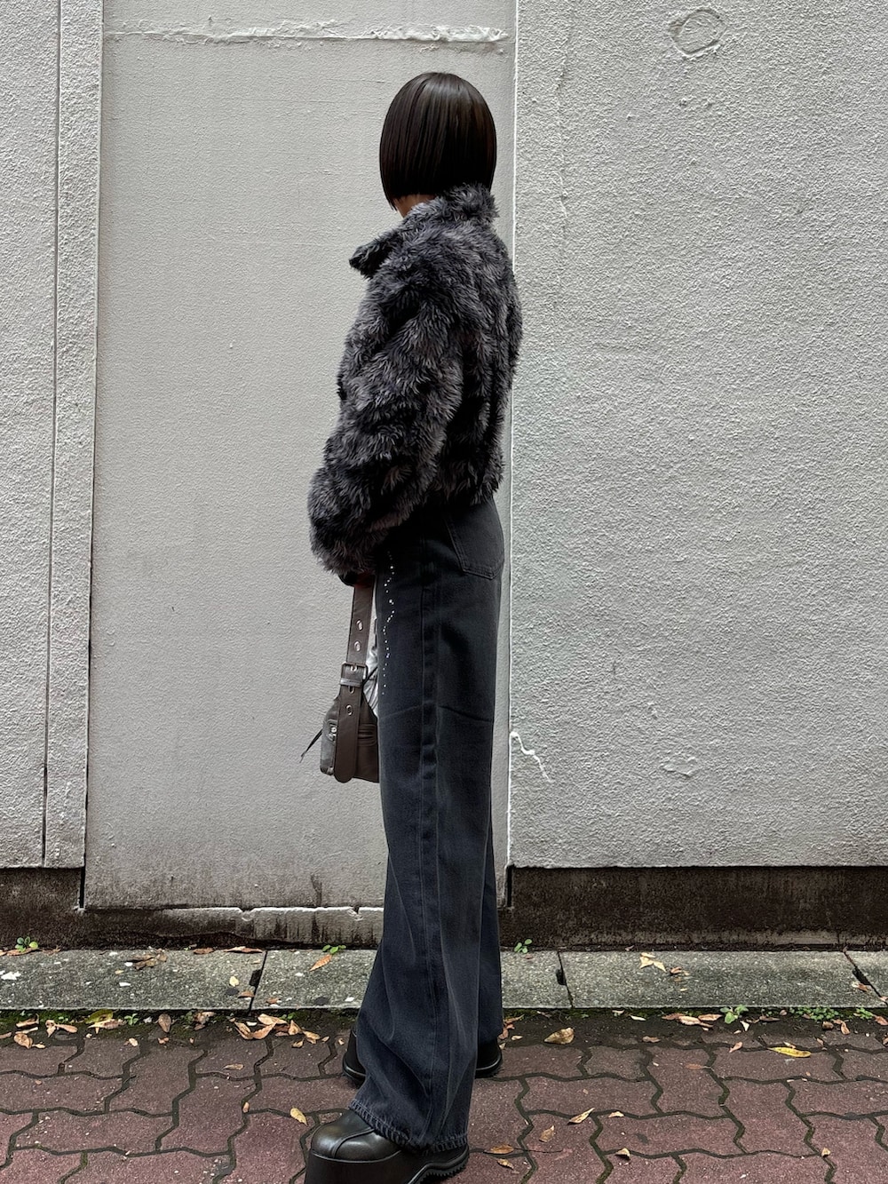 ブラック系のニット/セーター、ブラック系のデニムパンツ、その他のブルゾンを着用したレディースの秋コーディネートの2枚目の写真