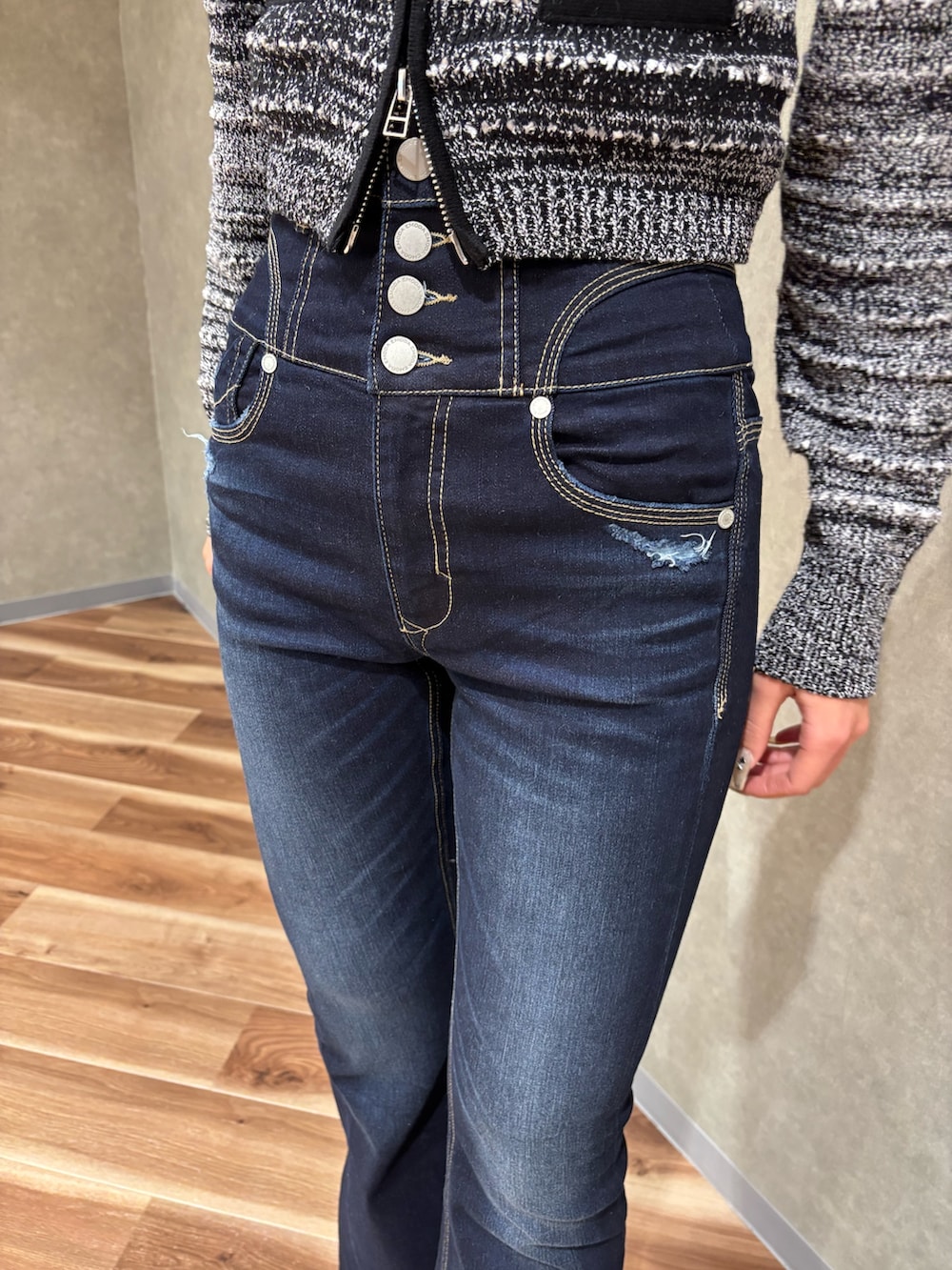 ブルー系のデニムパンツ、ブラック系のニット/セーター、ブラック系のブーツを着用したレディースの冬コーディネートの5枚目の写真