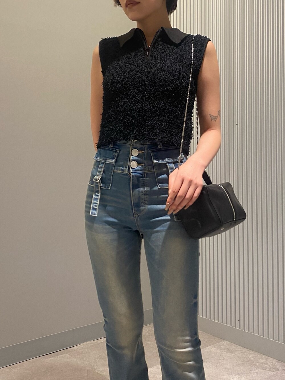 ブラック系のハンドバッグ、ブラック系のタンクトップ、ブルー系のデニムパンツを着用したレディースの夏コーディネートの4枚目の写真