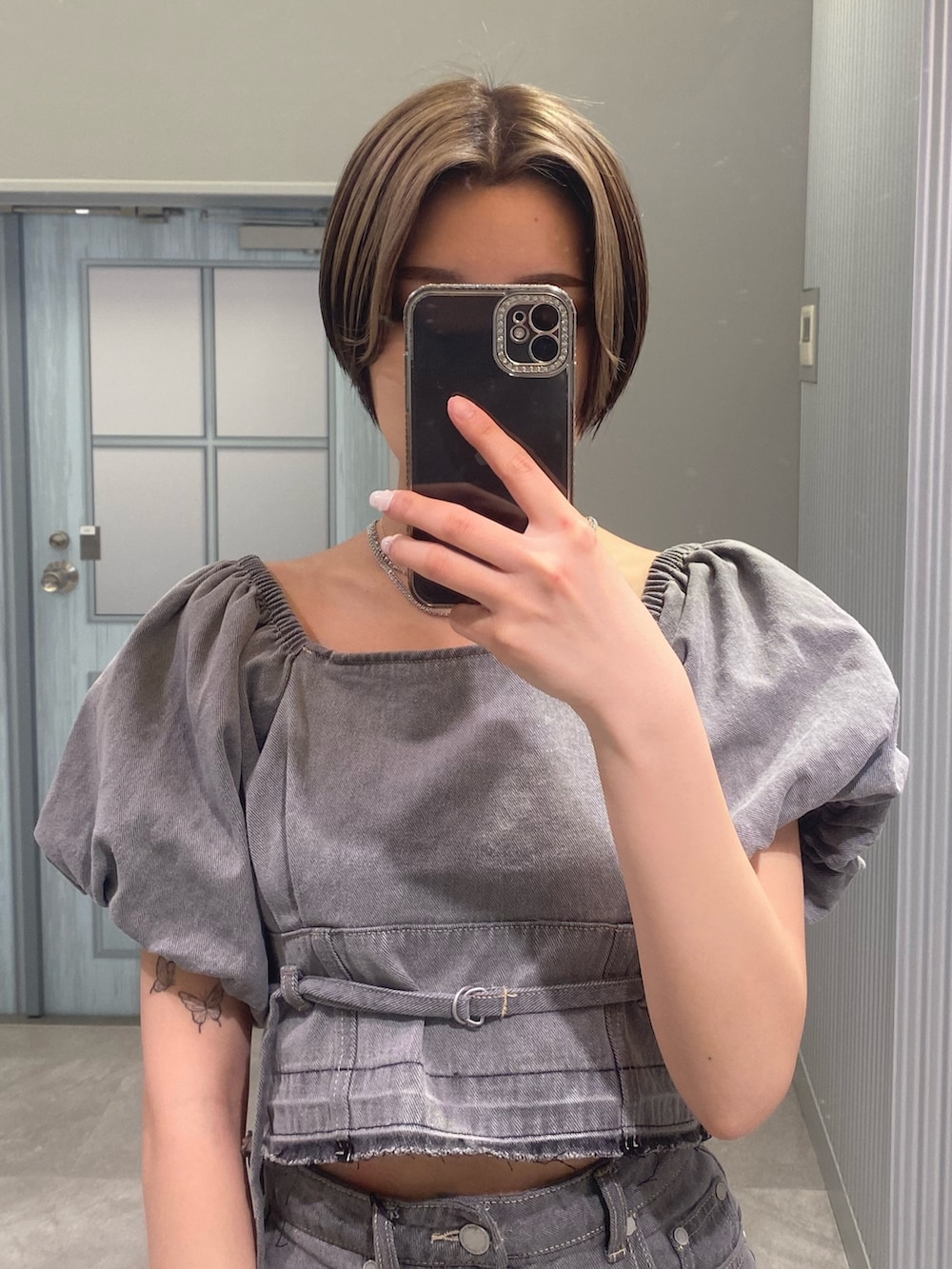 グレー系のシャツ/ブラウス、グレー系のスカート、ホワイト系のサンダルを着用したレディースの春コーディネートの5枚目の写真