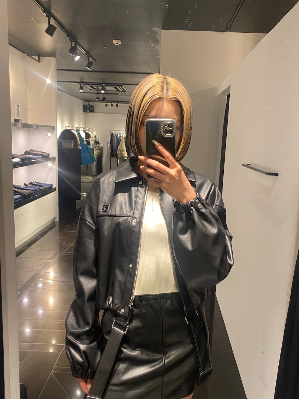 ブラック系のブーツ、ブラック系のスカート、ホワイト系のニット/セーターを着用したレディースの冬コーディネートの4枚目の写真