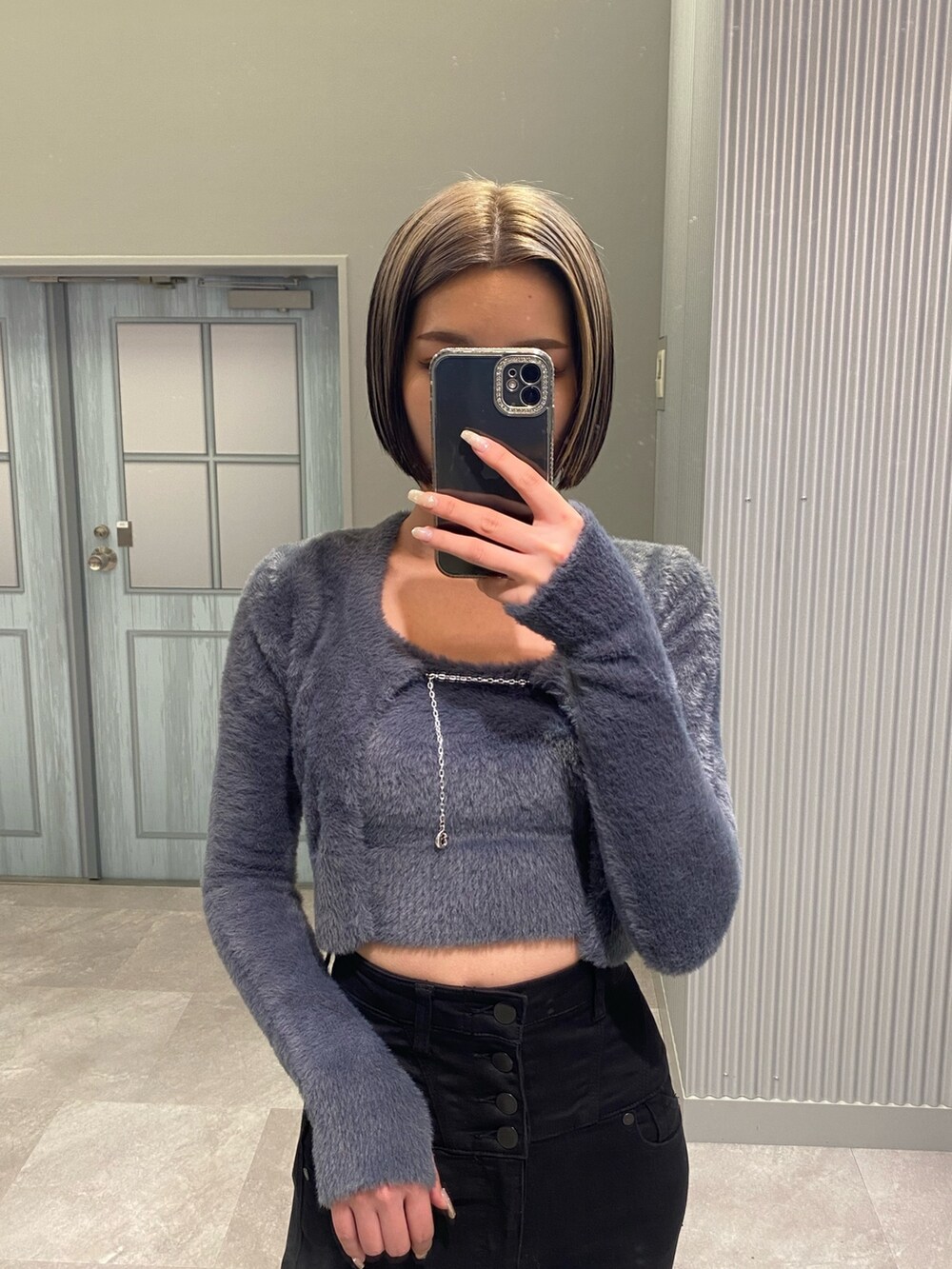 ブラック系のデニムパンツ、ブラック系のブーツ、グレー系のニット/セーターを着用したレディースの冬コーディネートの4枚目の写真