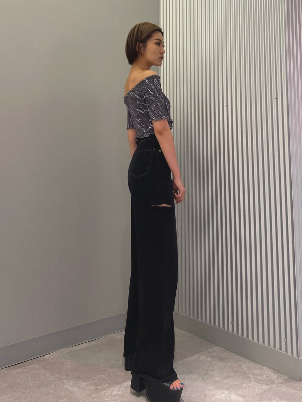 ブラック系のデニムパンツ、ブラック系のサンダル、その他のTシャツ/カットソーを着用したレディースの夏コーディネートの2枚目の写真