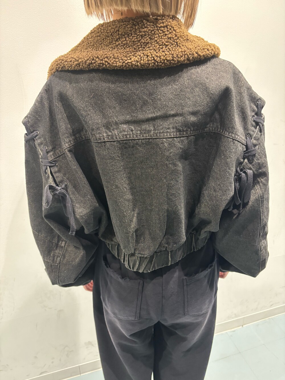 ブラック系のブーツ、ブラック系のブルゾン、ホワイト系のニット/セーターを着用したレディースの秋コーディネートの5枚目の写真