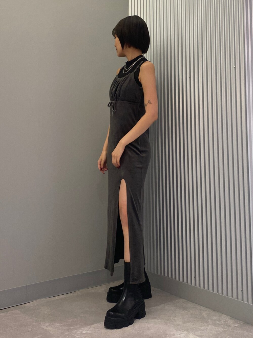 ブラック系のタンクトップ、グレー系のワンピース、ブラック系のブーツを着用したレディースの夏コーディネートの2枚目の写真