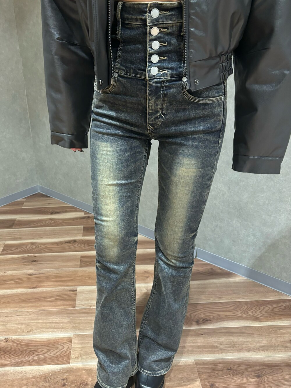 グレー系のブルゾン、ホワイト系のニット/セーター、ブルー系のデニムパンツを着用したレディースの秋コーディネートの5枚目の写真