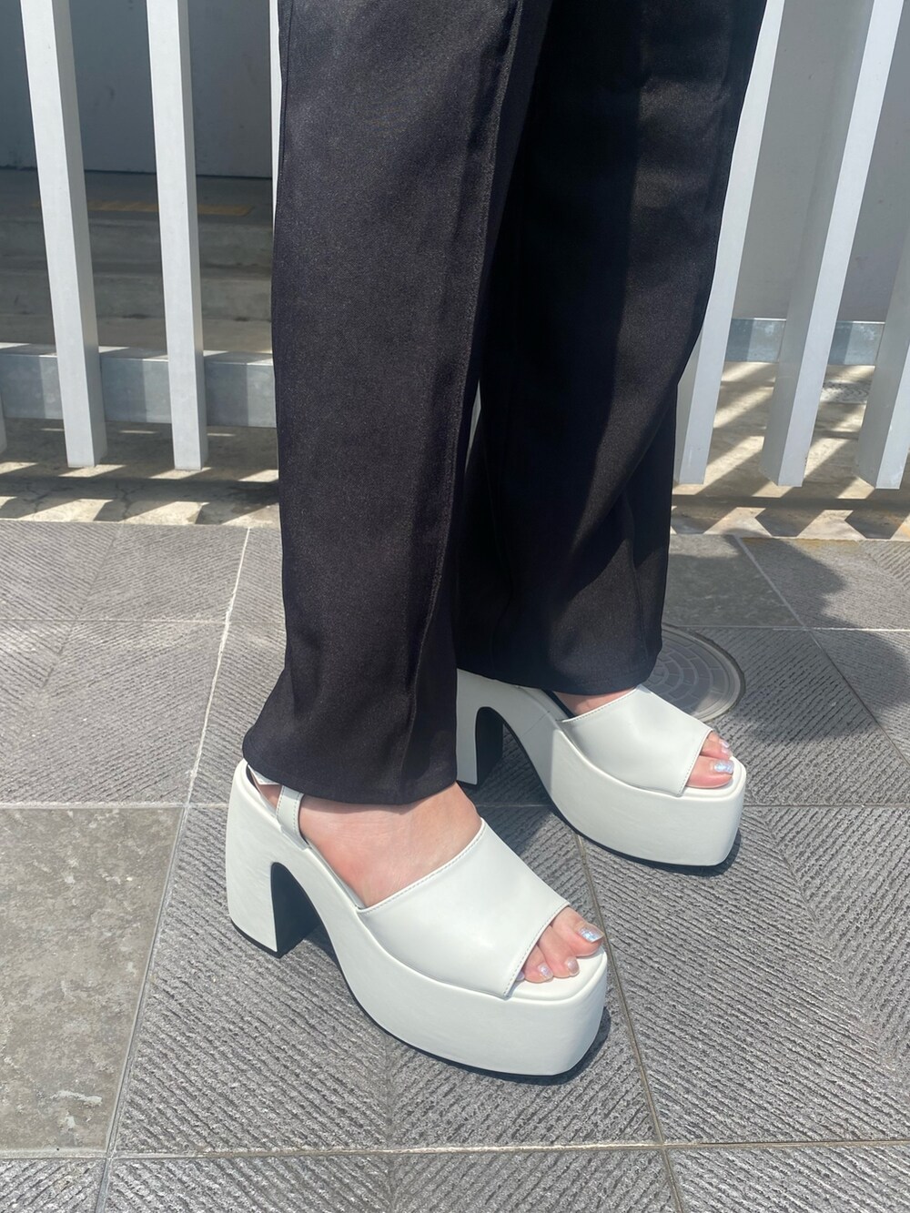 ブラック系のサロペット/オーバーオール、ホワイト系のサンダルを着用したレディースの夏コーディネートの6枚目の写真